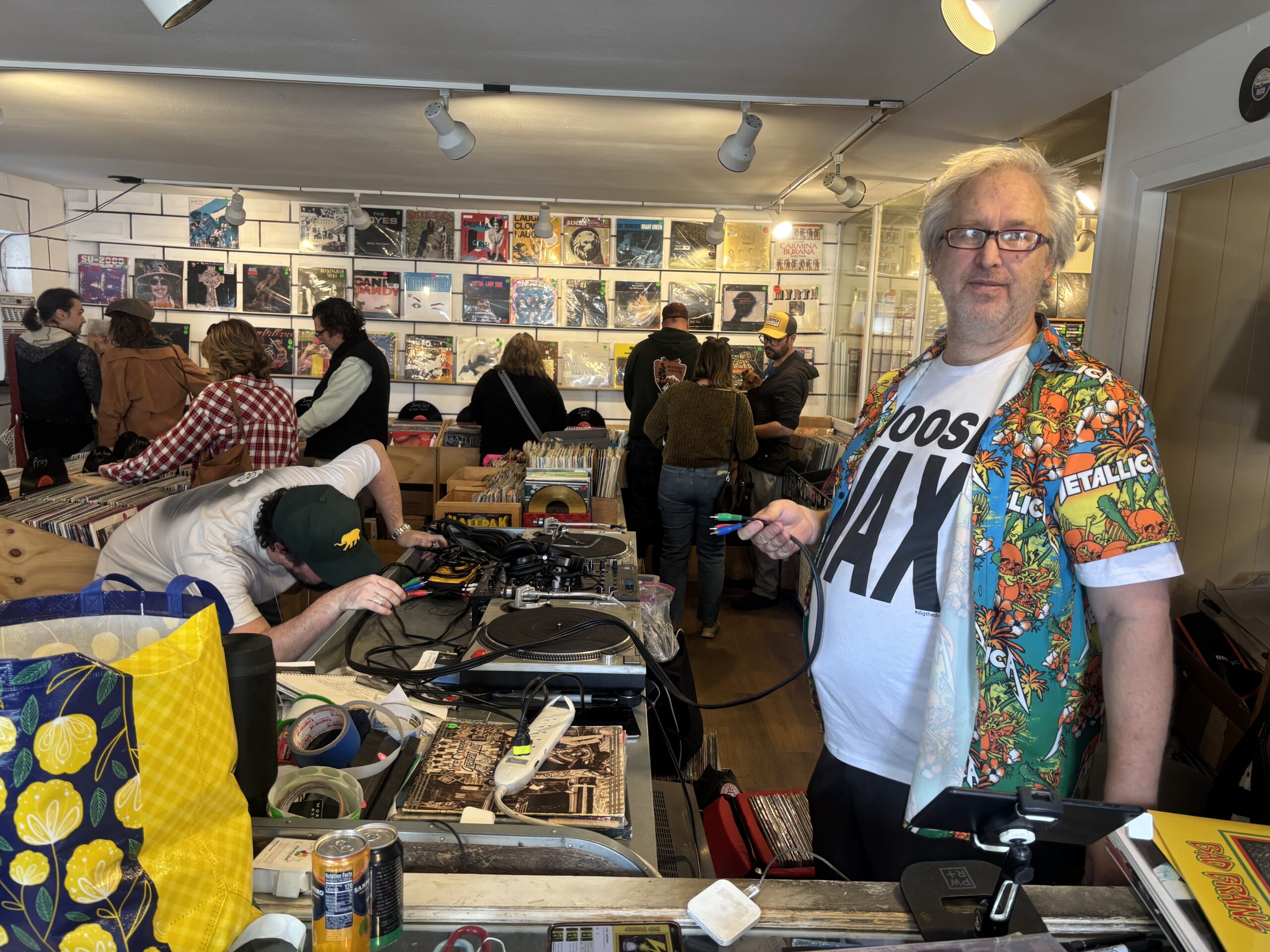 Dave at Invincible Vinyl in Denver, Colorado03 Invincible Vinyl owner Dave inside his Denver record store answering the phone among rows of vinyl records. Located in Denver’s Baker neighborhood, Invincible Vinyl has become a go-to destination for collectors, music lovers, and anyone searching for one of the best independent record stores in Colorado.