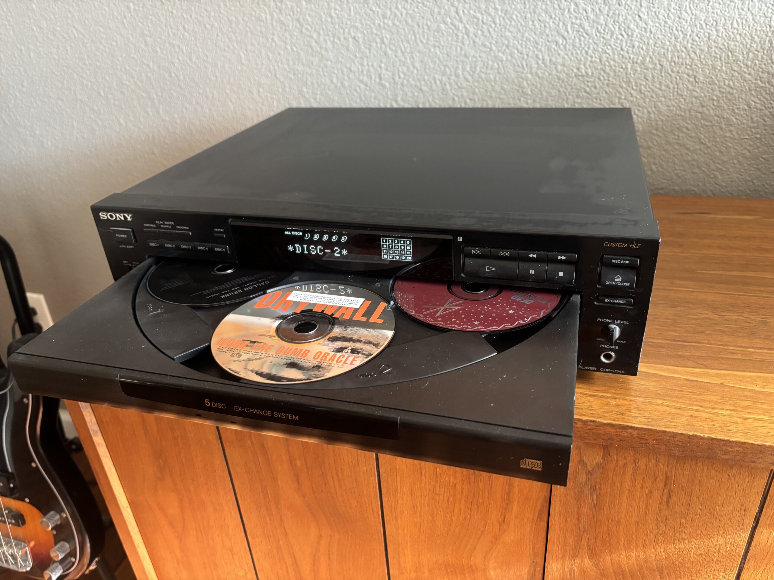 Sony 5-disc CD changer with the tray open, showing multiple CDs loaded inside a home stereo system.