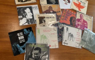 Stack of vintage 45 RPM vinyl records with large center holes and colorful record labels