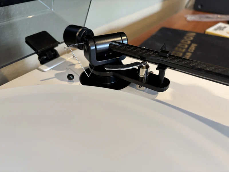 Close-up of the Fluance RT87 weight-based anti-skate system using a hanging counterweight for precise tracking force balance