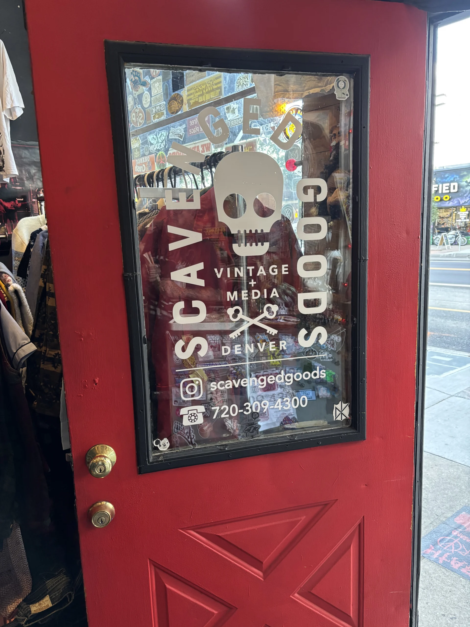 Scavenged Goods Vintage + Media Store Entrance – Denver, CO Scavenged Goods vintage and media store entrance on East Colfax Avenue in Denver featuring the iconic skull logo and red front door.
