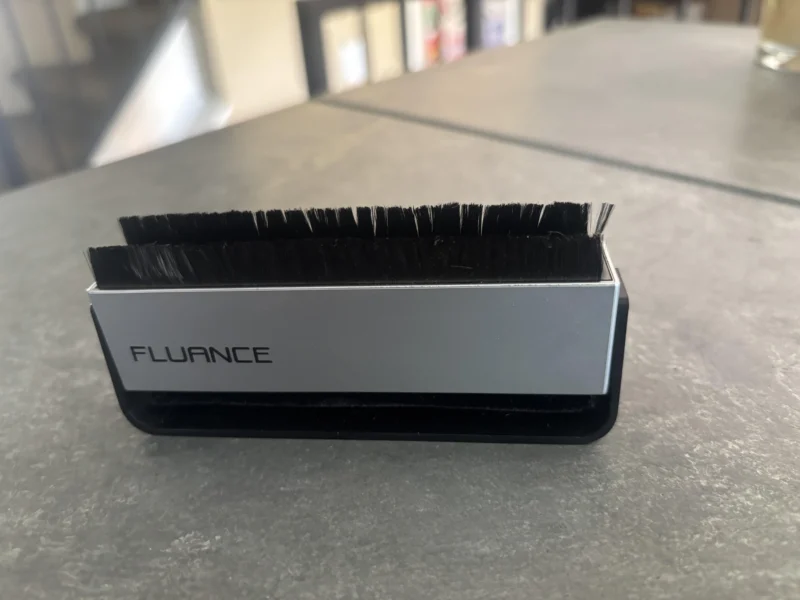 Fluance anti-static carbon fiber record brush removing dust from a vinyl record before playback.