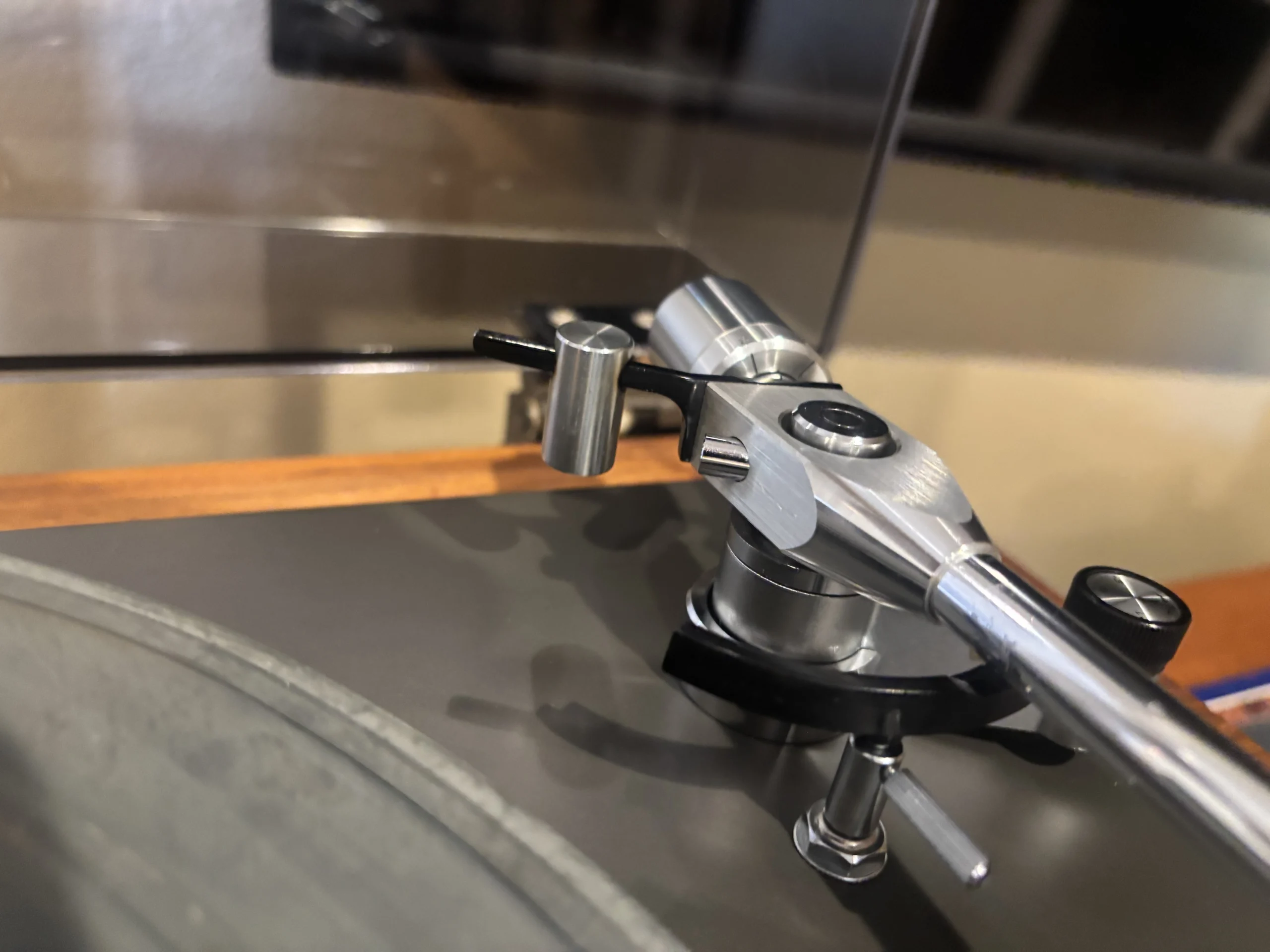 Spring-loaded anti-bias adjustment dial on a vintage turntable tonearm.