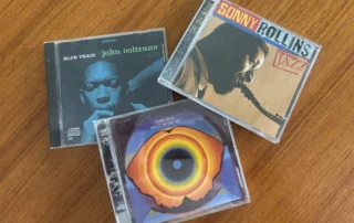 Three classic jazz CDs displayed on a wooden surface