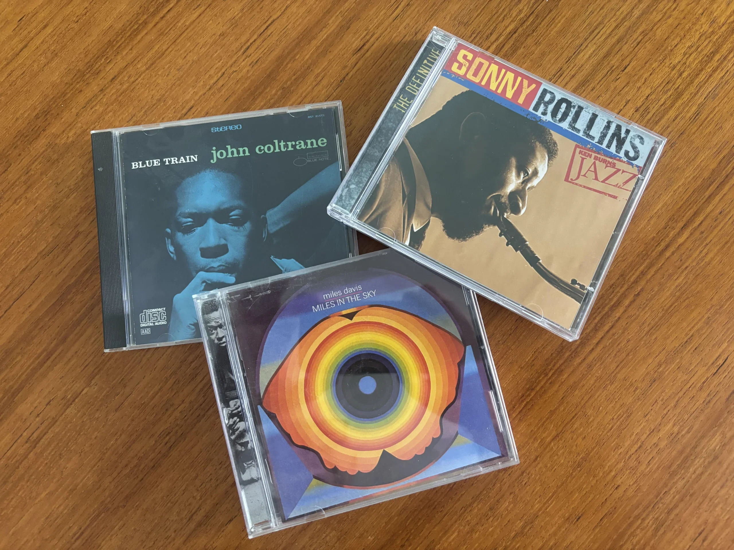 Three classic jazz CDs displayed on a wooden surface