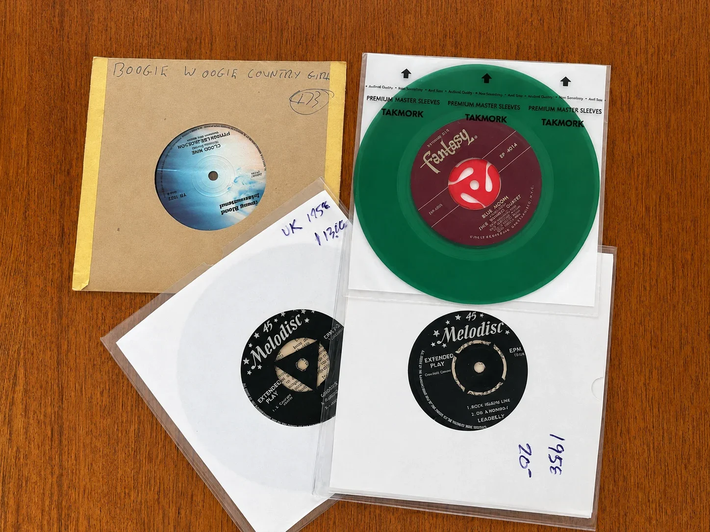 Vintage 45 RPM records and colored vinyl records in protective sleeves