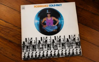 Sixto Rodriguez Cold Fact album cover on a teak table
