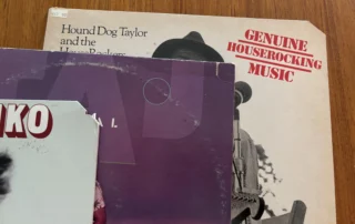 Three vinyl records showing common cutout markings, including corner cuts and a saw mark